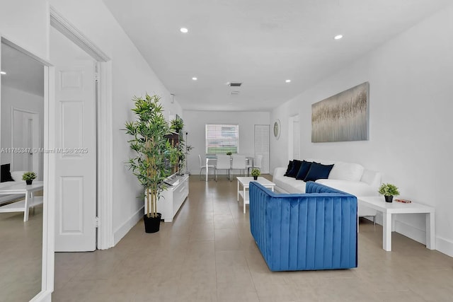 living area with recessed lighting, visible vents, and baseboards