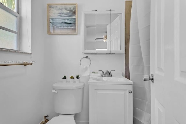 half bathroom featuring vanity, toilet, and ceiling fan