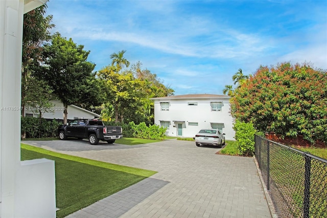 view of front of house featuring fence and a front lawn