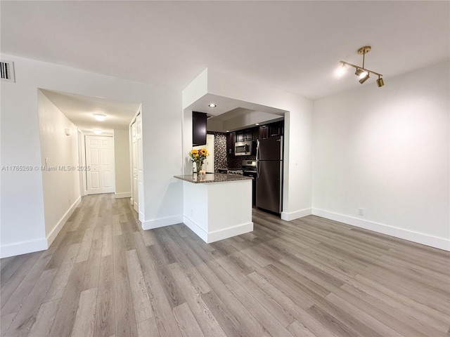 1601 S Flagler Dr Unit 211O, West Palm Beach, FL 33401 - kitchen with dark stone counters, wood finished floors, baseboards, a peninsula, and appliances with stainless steel finishes