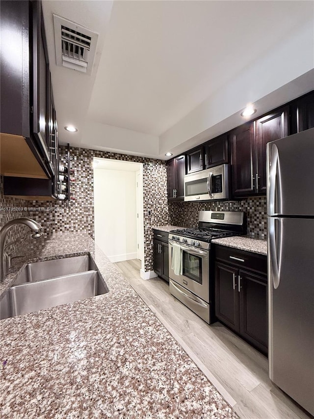 1601 S Flagler Dr Unit 211O, West Palm Beach, FL 33401 - kitchen featuring stainless steel appliances, light wood-style flooring, a sink, visible vents, and decorative backsplash