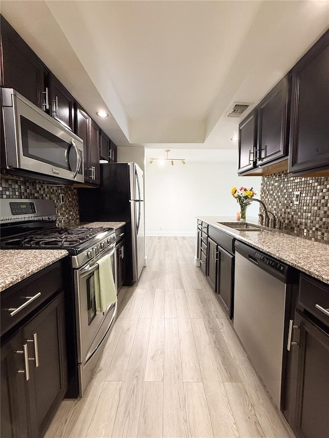 1601 S Flagler Dr Unit 211O, West Palm Beach, FL 33401 - kitchen featuring stainless steel appliances, visible vents, a sink, light wood-style floors, and decorative backsplash