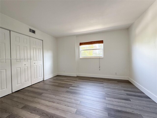 1601 S Flagler Dr Unit 211O, West Palm Beach, FL 33401 - unfurnished bedroom with visible vents, baseboards, dark wood-style floors, and a closet