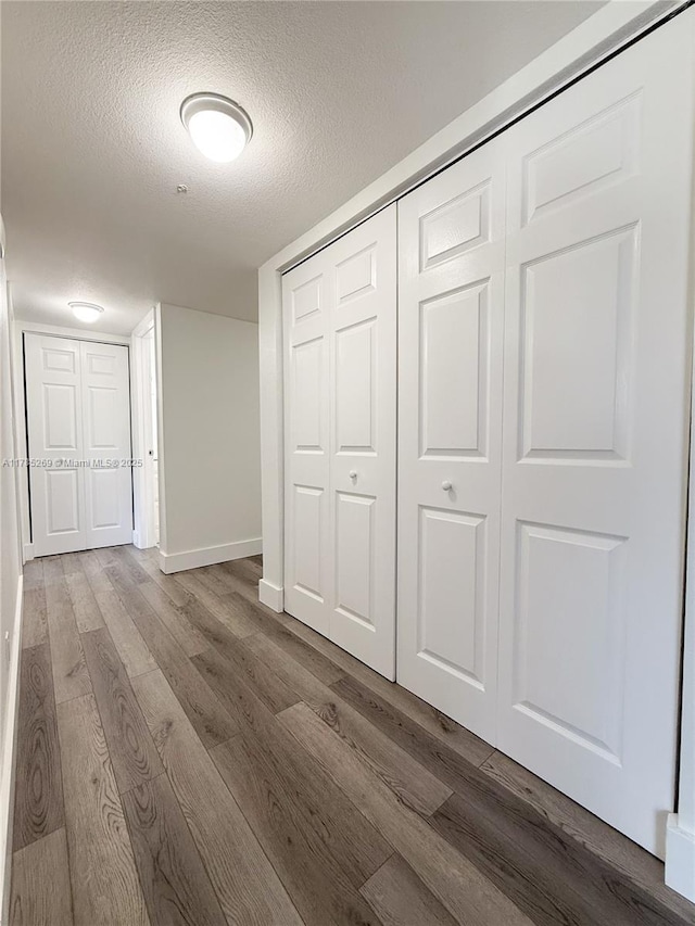 1601 S Flagler Dr Unit 211O, West Palm Beach, FL 33401 - unfurnished bedroom featuring baseboards, wood finished floors, a textured ceiling, and a closet