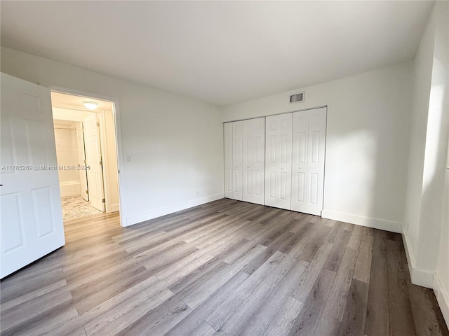 1601 S Flagler Dr Unit 211O, West Palm Beach, FL 33401 - unfurnished bedroom with baseboards, wood finished floors, visible vents, and a closet