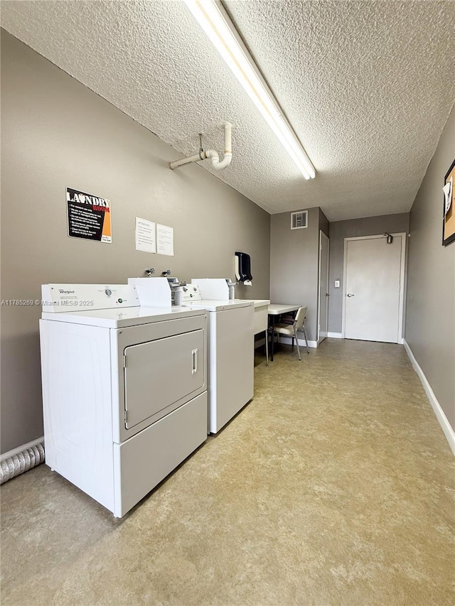 1601 S Flagler Dr Unit 211O, West Palm Beach, FL 33401 - laundry area featuring washing machine and clothes dryer, light carpet, a textured ceiling, baseboards, and visible vents