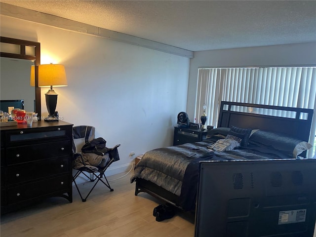 202 Lake Pointe Dr Unit 105, Oakland Park, FL 33309 - bedroom with light wood finished floors, a textured ceiling, and baseboards