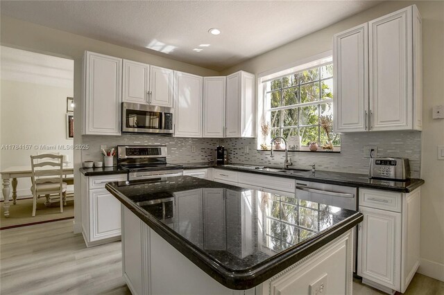 4322 Fox Ridge Dr, Weston, FL 33331 - kitchen featuring stainless steel appliances, light wood-style flooring, white cabinets, tasteful backsplash, and recessed lighting