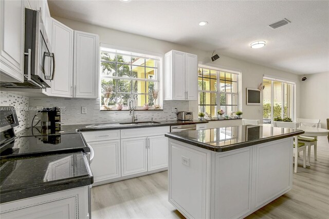 4322 Fox Ridge Dr, Weston, FL 33331 - kitchen featuring a sink, stainless steel appliances, light wood-style floors, tasteful backsplash, and a kitchen island