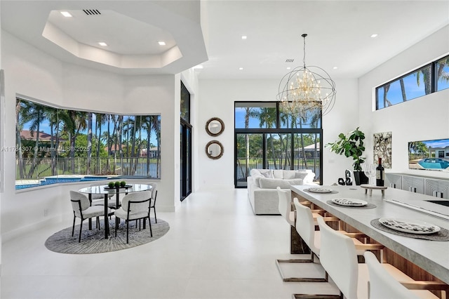 dining space with visible vents, recessed lighting, a notable chandelier, and a high ceiling