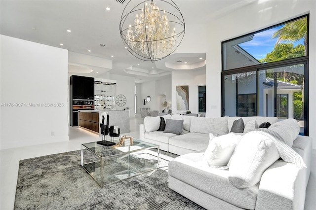 living room with recessed lighting, a high ceiling, a notable chandelier, and visible vents
