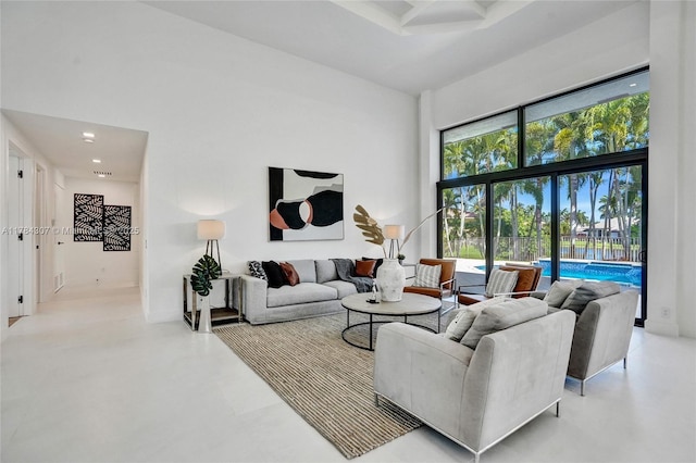 living room featuring recessed lighting, a high ceiling, and concrete floors