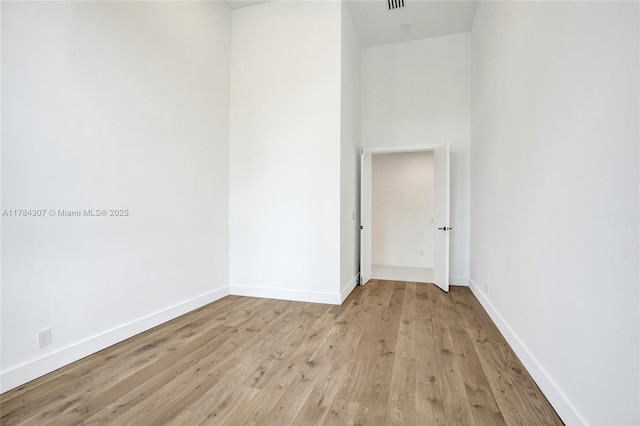 unfurnished room with light wood finished floors and baseboards