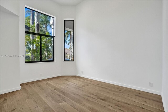 spare room with wood finished floors and baseboards