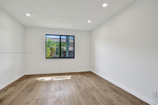 spare room featuring wood finished floors, recessed lighting, and baseboards