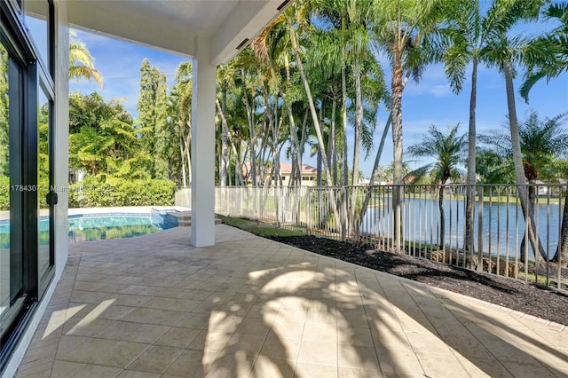 view of patio with fence, a water view, and a fenced in pool