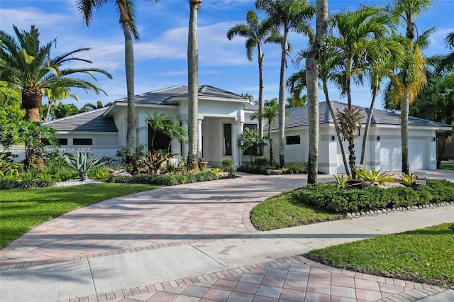 view of front of home with a garage, stucco siding, and decorative driveway
