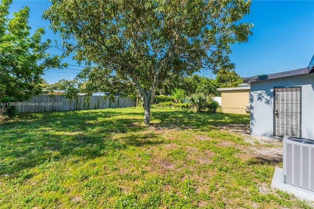 view of yard with central AC unit and fence