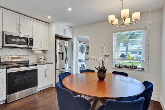 dining room featuring stacked washer / drying machine, recessed lighting, dark wood-style flooring, and an inviting chandelier