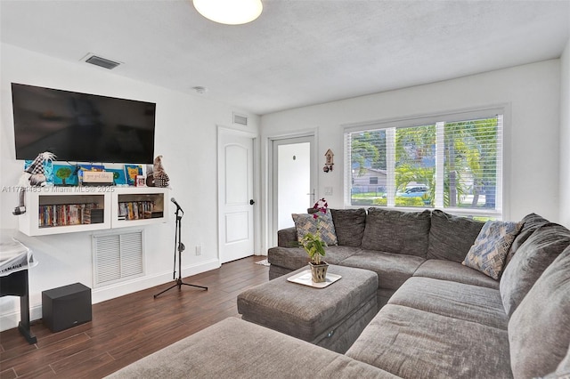 living area with visible vents and wood finished floors