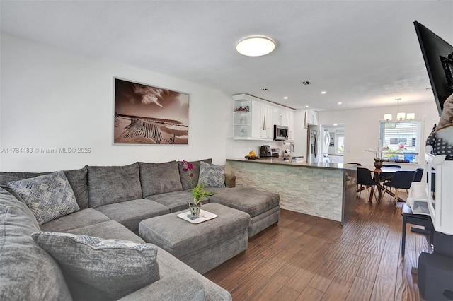 living room featuring an inviting chandelier, dark wood-style flooring, and recessed lighting