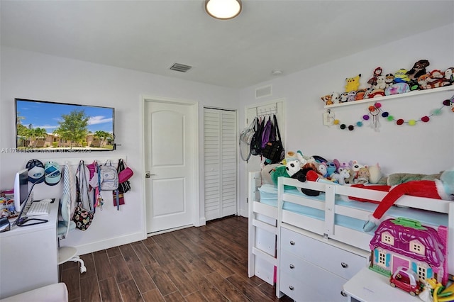 bedroom featuring baseboards, visible vents, a closet, and dark wood finished floors