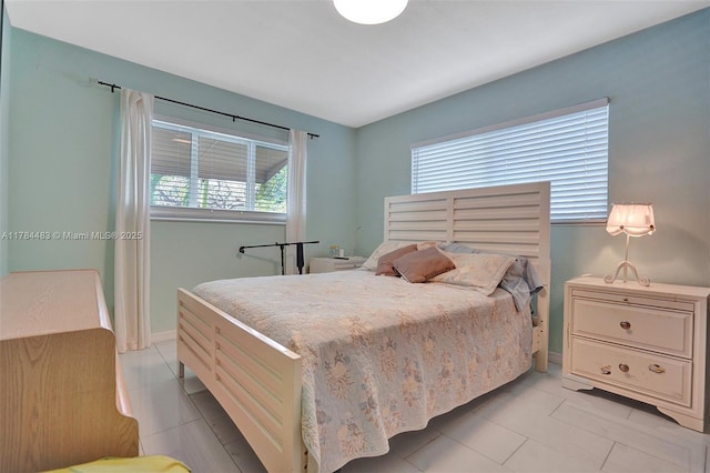 bedroom with light tile patterned flooring and baseboards