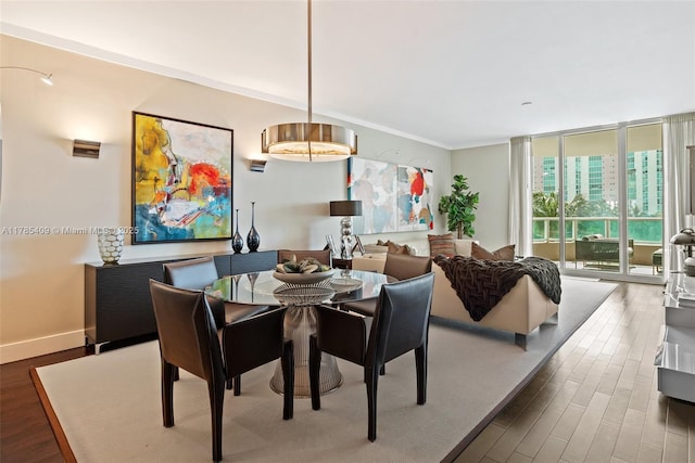 dining room with crown molding, wood finished floors, baseboards, and expansive windows