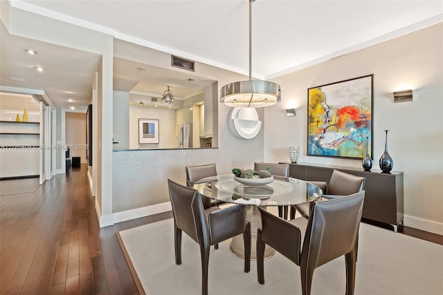 dining area featuring visible vents, baseboards, and hardwood / wood-style flooring