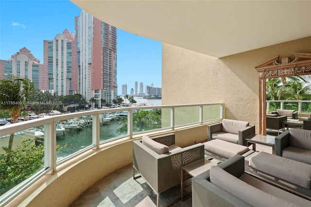 balcony featuring a water view, outdoor lounge area, and a city view