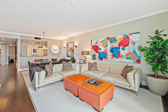 living room with crown molding, wood finished floors, and baseboards