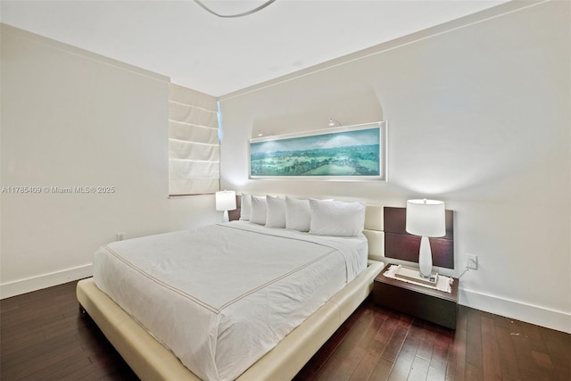 bedroom featuring baseboards and hardwood / wood-style flooring
