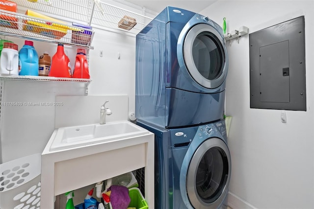 washroom featuring stacked washer and dryer, laundry area, and electric panel