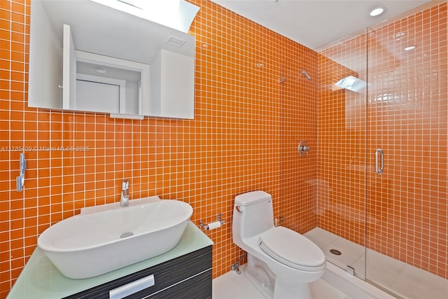 bathroom with tile walls, toilet, and a shower stall