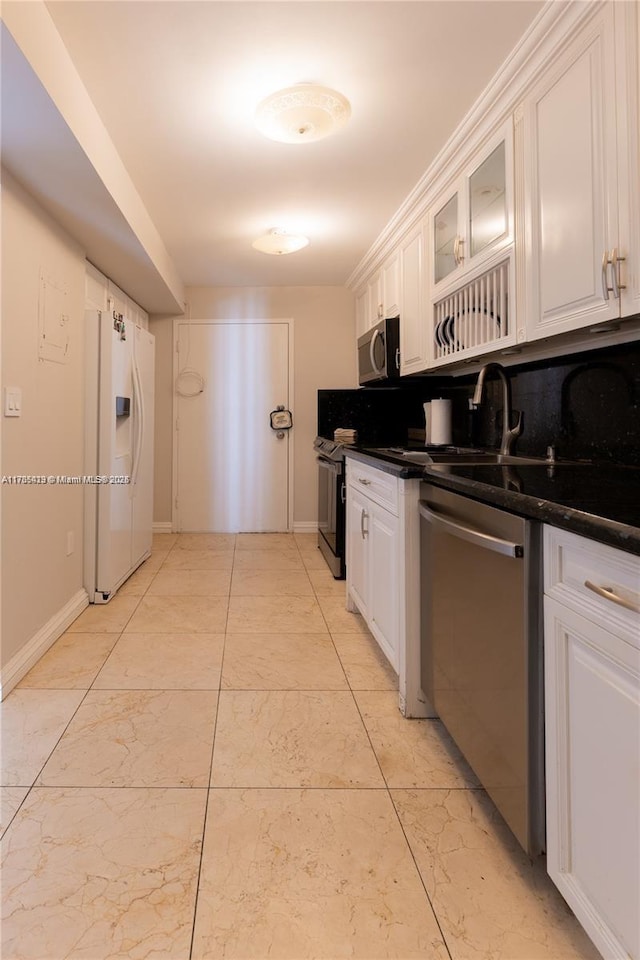 18011 Biscayne Blvd Unit 902, Aventura, FL 33160 - kitchen with appliances with stainless steel finishes, white cabinets, dark countertops, and glass insert cabinets