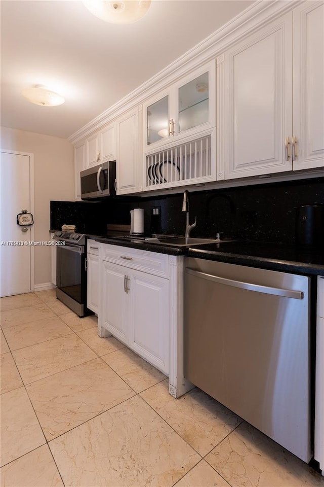 18011 Biscayne Blvd Unit 902, Aventura, FL 33160 - kitchen featuring appliances with stainless steel finishes, decorative backsplash, white cabinets, dark countertops, and a sink