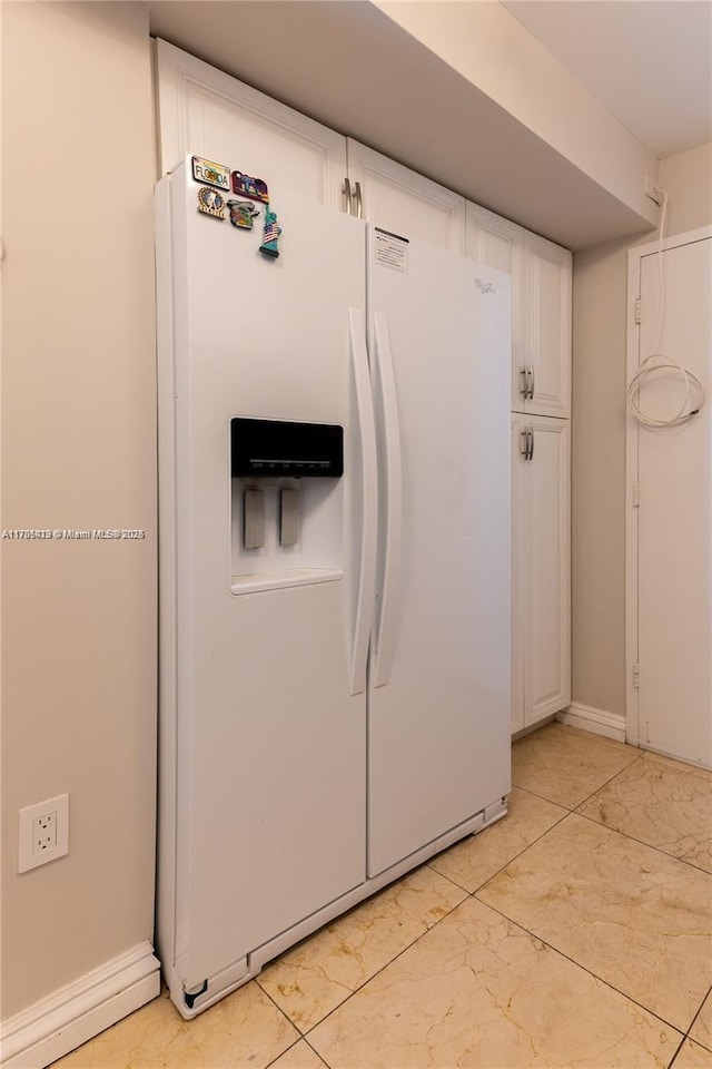 18011 Biscayne Blvd Unit 902, Aventura, FL 33160 - detailed view of white fridge with ice dispenser, white cabinetry, and baseboards