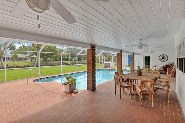 15801 SW 77th Ct, Palmetto Bay, FL 33157 - swimming pool featuring ceiling fan, a patio, glass enclosure, a lawn, and outdoor dining area