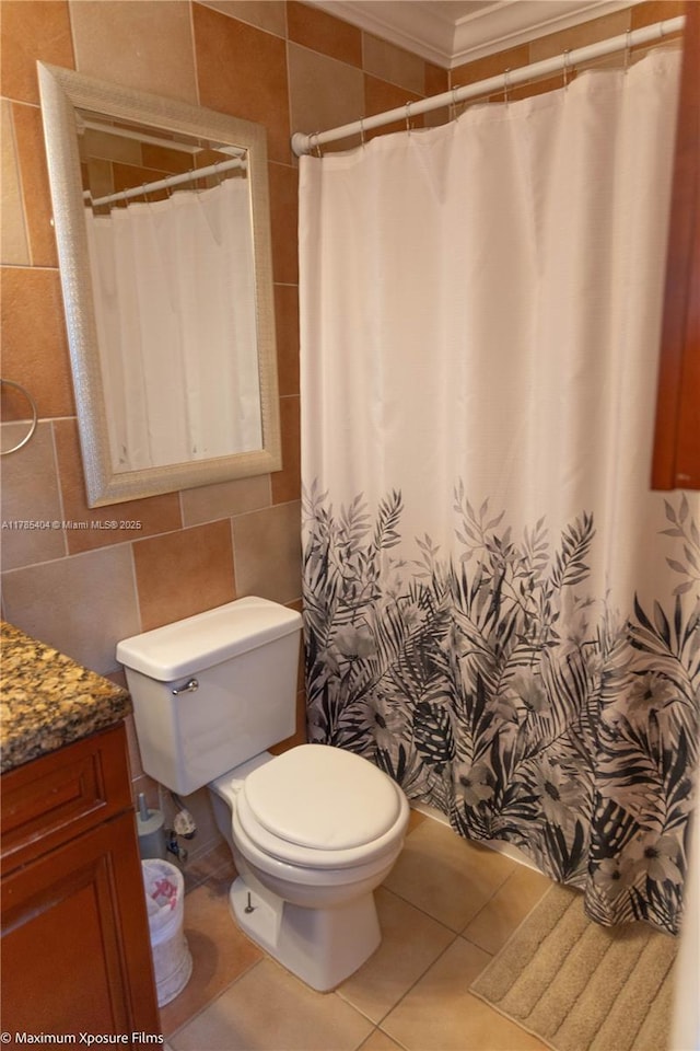 bathroom featuring tile walls, toilet, crown molding, vanity, and tile patterned flooring