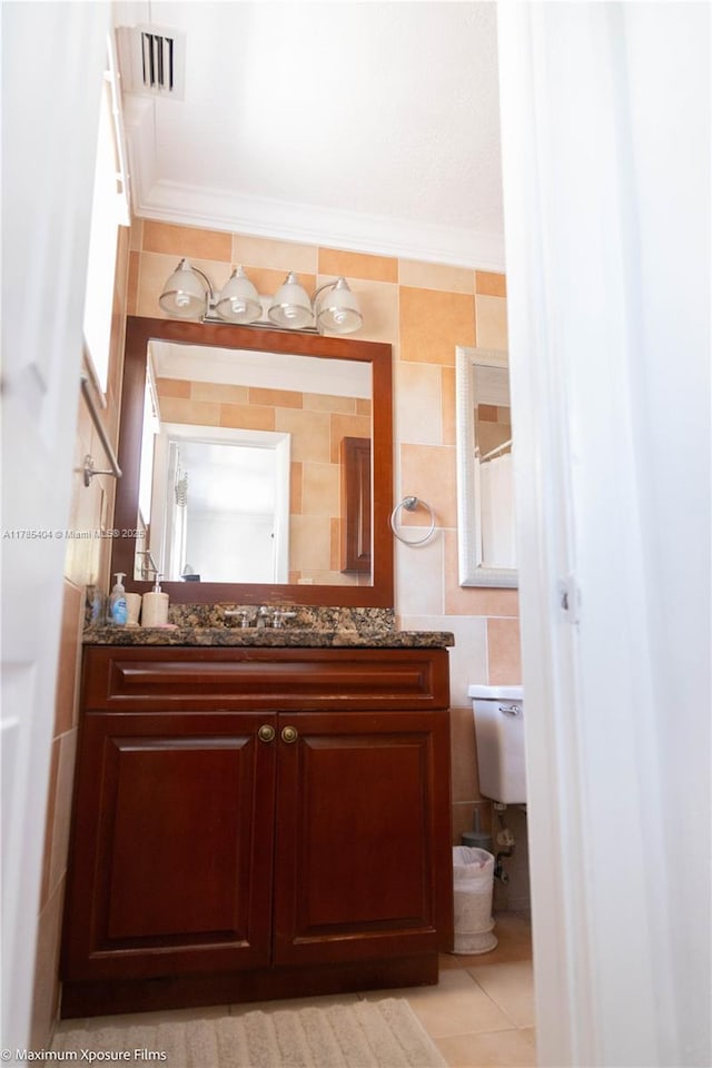 bathroom with vanity, visible vents, tile walls, and toilet