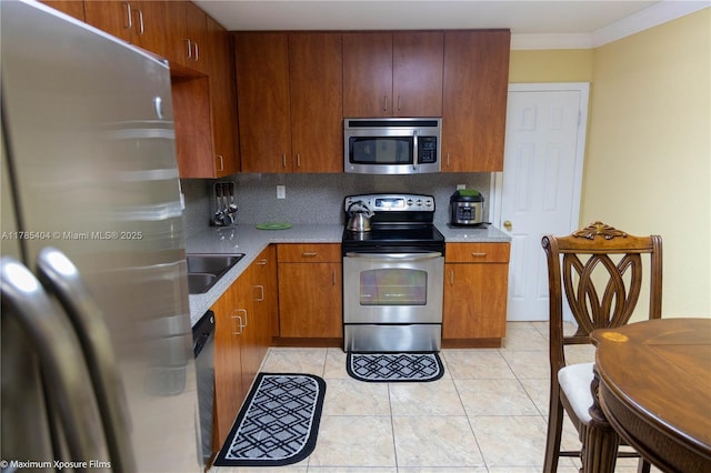 kitchen featuring a sink, light countertops, decorative backsplash, and stainless steel appliances