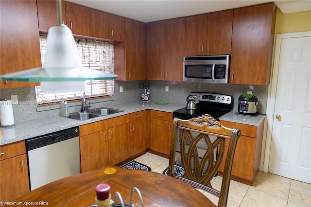 kitchen with tasteful backsplash, light countertops, light tile patterned flooring, stainless steel appliances, and a sink