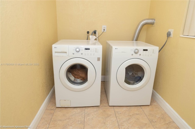 clothes washing area featuring baseboards, light tile patterned floors, independent washer and dryer, and laundry area