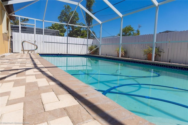 view of pool featuring a fenced backyard, glass enclosure, and a fenced in pool