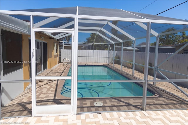 view of pool featuring a fenced in pool, a patio area, a fenced backyard, and glass enclosure
