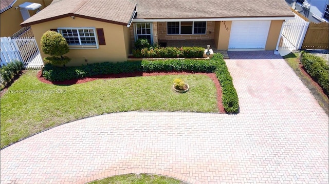 single story home with roof with shingles, stucco siding, decorative driveway, an attached garage, and a front lawn