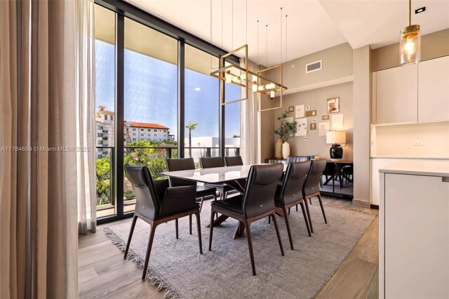 3581 E Glencoe St Unit 309, Miami, FL 33133 - dining room featuring light wood-style flooring, visible vents, and floor to ceiling windows
