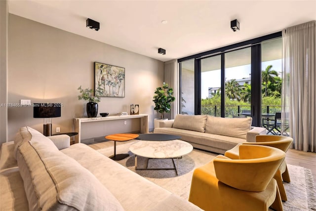 3581 E Glencoe St Unit 309, Miami, FL 33133 - living room featuring floor to ceiling windows and wood finished floors