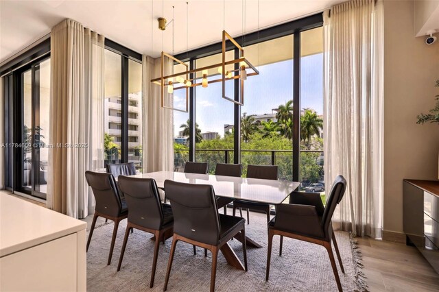 3581 E Glencoe St Unit 309, Miami, FL 33133 - dining space featuring a chandelier, wood finished floors, and floor to ceiling windows