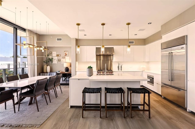 3581 E Glencoe St Unit 309, Miami, FL 33133 - kitchen featuring built in refrigerator, wall oven, modern cabinets, and wood finished floors